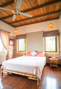 顺化Lagom Home的一间卧室设有一张大床和两个窗户。