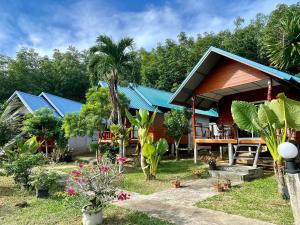 俊穆岛Happy Home Kohjum的拥有蓝色屋顶、植物和树木的度假胜地