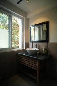 顺化Lagom Home的浴室设有水槽和镜子,位于柜台上