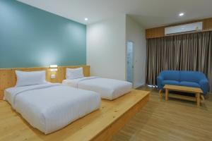 Ban PhayomMOODs Boutique Hotel的一间卧室配有两张床和一张蓝色椅子
