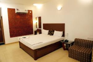 马尔万Blue Sea Beach Resort Malvan的一间卧室配有一张床和一把椅子