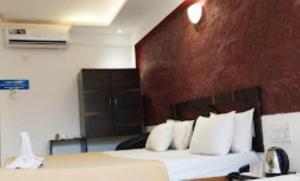 马尔万Blue Sea Beach Resort Malvan的配有白色枕头的床的酒店客房