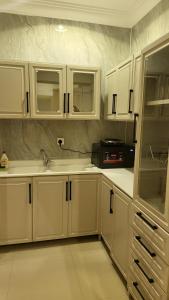 利雅德شقة فاخرة VIP حي الوادي的厨房配有白色橱柜和水槽