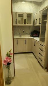 利雅德شقة فاخرة VIP حي الوادي的厨房配有白色橱柜和花瓶