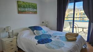 托罗克斯科斯塔The Beach Penthouse的一间卧室配有一张带蓝色枕头的床和一个阳台