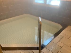 小樽Plum House Otaru的浴室设有装满水的浴缸。