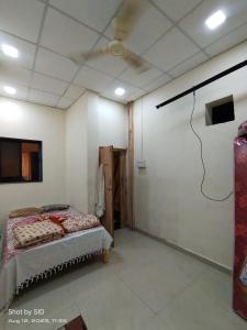潘达尔普尔Shree Radhesh Bhakt Niwas的一间带风扇的客房内一张床的卧室