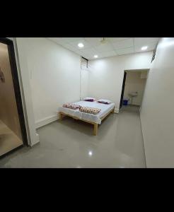 潘达尔普尔Shree Radhesh Bhakt Niwas的卧室位于客房的角落,配有一张床