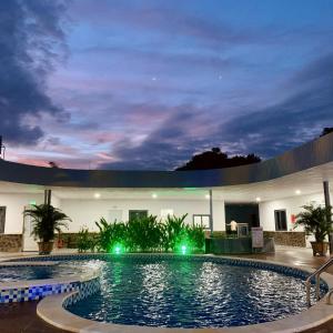 Xóm Phước MỹKhách sạn Khang Điền 2的一座游泳池,晚上与大楼相连