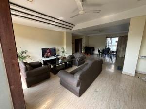 古瓦哈提Sushrita Hillview Homestay的客厅配有两张沙发和一台电视机