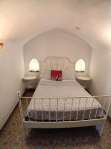 瓜迪克斯Cueva La Ermita II的一间卧室,配有带2个床头柜的床