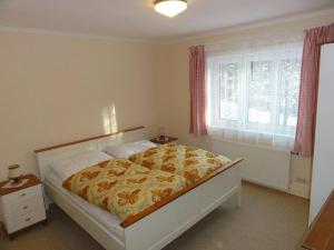 巴德米滕多夫Ferienhaus Reith的一间卧室配有一张黄色和白色毯子的床