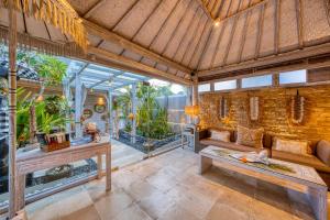 勒吉安Bali Cosy Villa Adults Only的一个带沙发和一些植物的温室