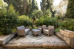 耶路撒冷Historic 4-Bedroom Gem with Private Garden, Steps from Old City & Mamila Complex的花园内带桌椅的庭院