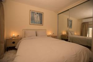 耶路撒冷Historic 4-Bedroom Gem with Private Garden, Steps from Old City & Mamila Complex的卧室配有白色的床和两盏灯。