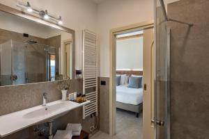 Illasi圣费利切运动酒店的一间带水槽和镜子的浴室以及一张床