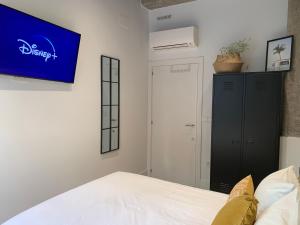 瓦伦西亚La Reina Beach rooms的卧室配有一张床,墙上配有电视。