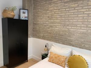 瓦伦西亚La Reina Beach rooms的卧室设有砖墙,毗邻一张床