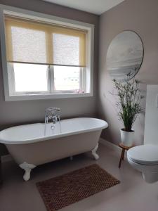 迪温特Sfeervolle woning dichtbij centrum Deventer的带窗户的浴室内的白色浴缸