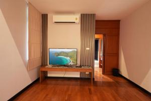 乔木提恩海滩รมิดา พูล วิลล่า พัทยา Ramida Pool Villa Pattaya的一间客厅,配有一张桌子上放的电视