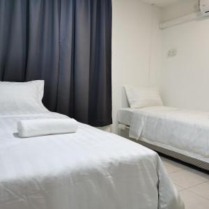 拉布安Hotel Seroja的配有蓝色窗帘的客房内的2张白色床