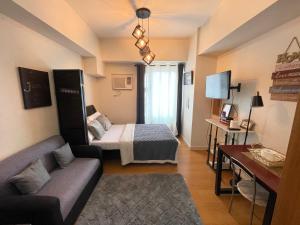 马尼拉Modern and Cozy Condo in 8Adriatico near PGH, SLMEC and US Embassy #31Q的客厅配有一张床和一张沙发