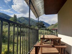 KegetiKegeti Panorama Holiday Chalet的木制阳台设有野餐桌和山脉