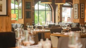 什平德莱鲁夫姆林萨沃伊皇家酒店的餐厅设有木桌和椅子,配酒杯