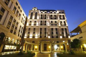 竹南苗栗馥艺金郁金香酒店的一座白色的大建筑,晚上有灯