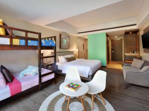 勒吉安巴厘勒吉安美居酒店的客房设有两张双层床和一张沙发。