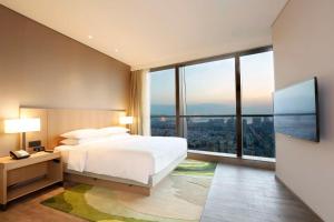 三亚三亚中心凯悦嘉轩酒店（网红空中泳池打卡）的一间卧室设有一张床和一个大窗户