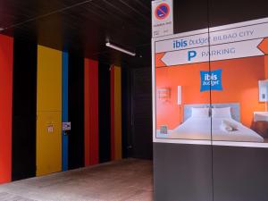 毕尔巴鄂Ibis Budget Bilbao City的一间拥有色彩缤纷的墙壁和一张显示床的房间