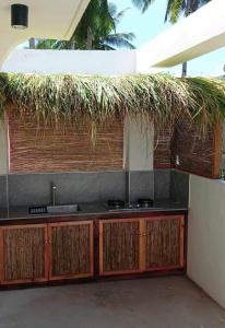 卢纳将军城Siargao Residency by Privacy Group的一个带水槽和草屋顶的厨房