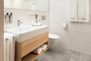 劳特阿赫Hotel Johann Lauterach的白色的浴室设有水槽和卫生间。