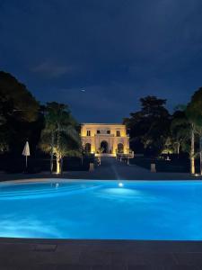 奥尼萨诺Villa Di Noi的大楼前的大型蓝色游泳池