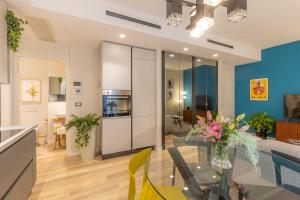 维罗纳Orti Manara Design Apartments的厨房以及带玻璃桌的起居室。
