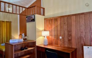 Calheta Do MaioPalombella - Stella Maris Exclusive的客房设有木墙和一张带台灯的书桌。