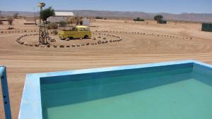 基特曼斯胡普Canyon Farmyard Camping的停在沙漠中间的黄色货车
