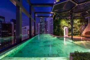 吉隆坡Hotel Indigo Kuala Lumpur on the Park, an IHG Hotel的一座城市天际线建筑屋顶上的游泳池