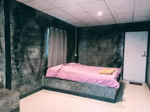 拜县排森林度假村 的卧室配有一张黑色墙壁上的粉红色床