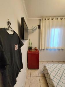 索罗卡巴Quando cama Solteiro的一间房间,墙上挂着一张床和一件衬衫
