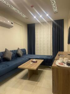 安曼Antalya Hotel Amman的客厅配有蓝色的沙发和桌子