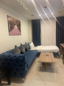 安曼Antalya Hotel Amman的客厅配有蓝色的沙发和桌子