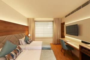 新德里印度必兹诺酒店的配有一张床和一张书桌的酒店客房