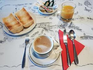 塞普尔韦达Hotel Puerta Sepúlveda的一张桌子,上面放着一杯咖啡和两盘烤面包