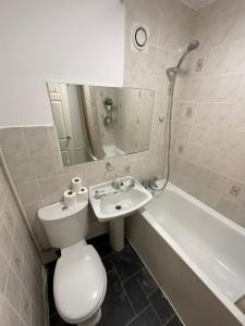 伦敦Spacious 2 bed Dulwich flat green views的浴室配有卫生间、盥洗盆和浴缸。