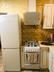 乌曼岛Julia的厨房配有炉灶和白色冰箱。