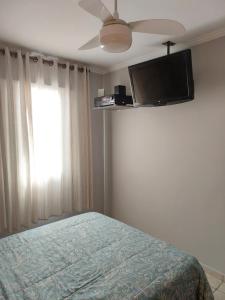 索罗卡巴Quarto com Cama de Casal的一间卧室配有一张床和一台平面电视