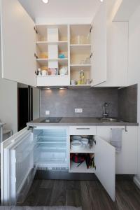 里加Mini dzīvoklis-atbilstoša cena的厨房配有白色橱柜和水槽