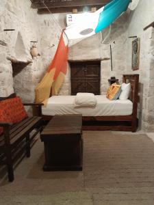 塞拉莱نزل كوفان التراثي Koofan Heritage Lodge的一间卧室配有一张床,卧室配有长凳